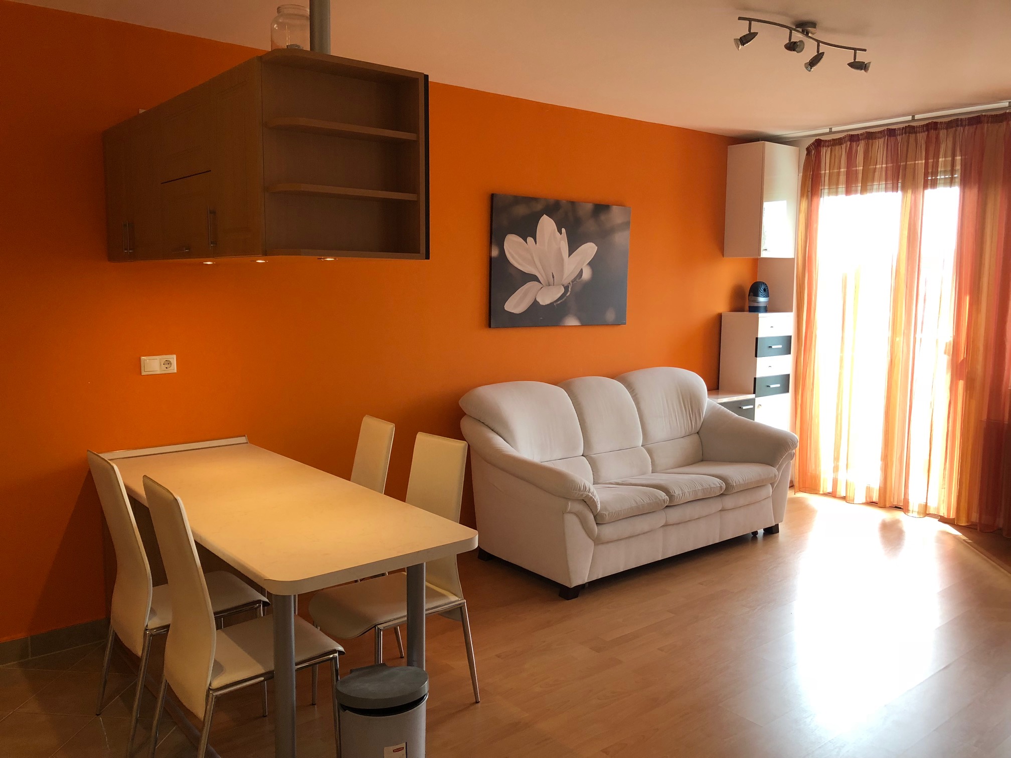 Dark, low-key photograph of a living area in deep shadow with a warm accent wall
